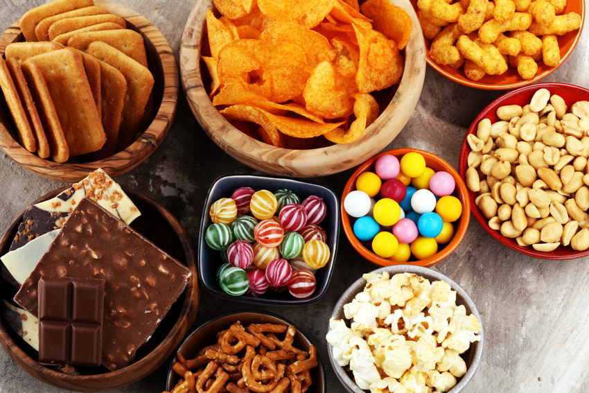 Assorted sweet and salty snacks in bowls.